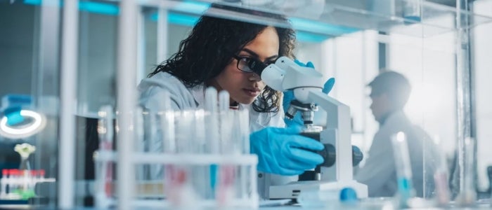 nurse researcher looking into microscope