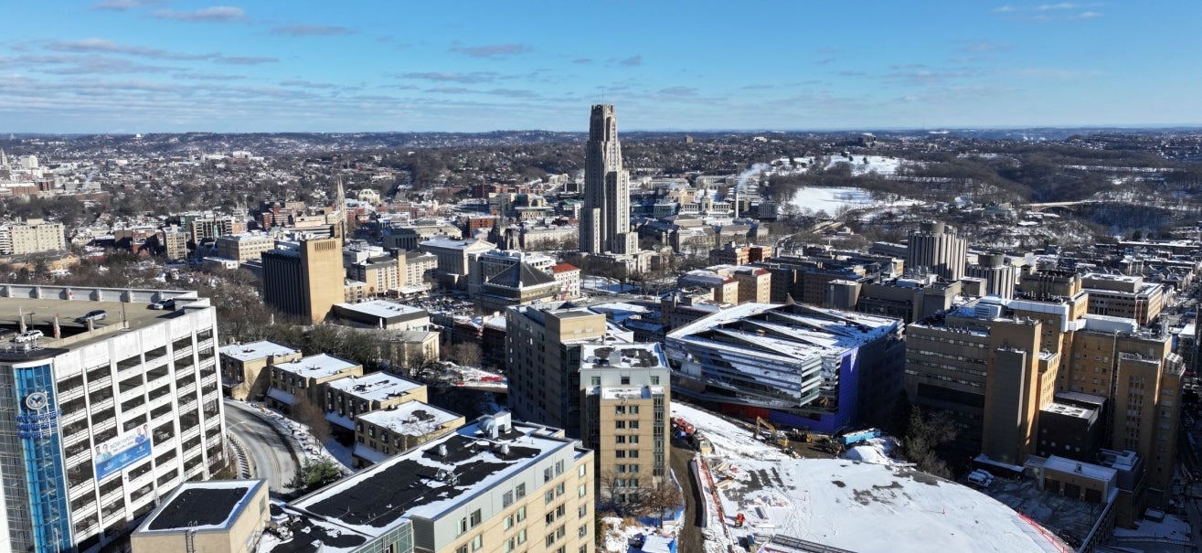 aerial photo of Pitt campus in winter with snow on buildings