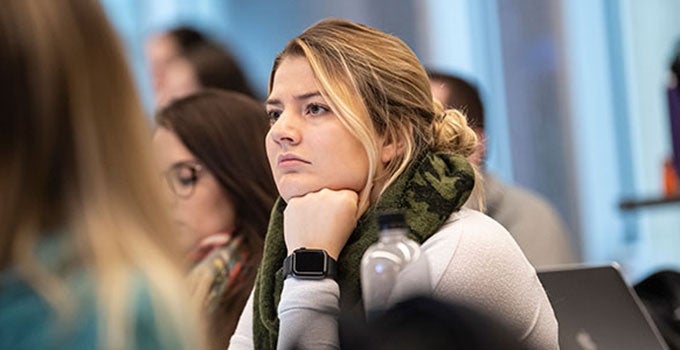 student in lecture resting chin on hand