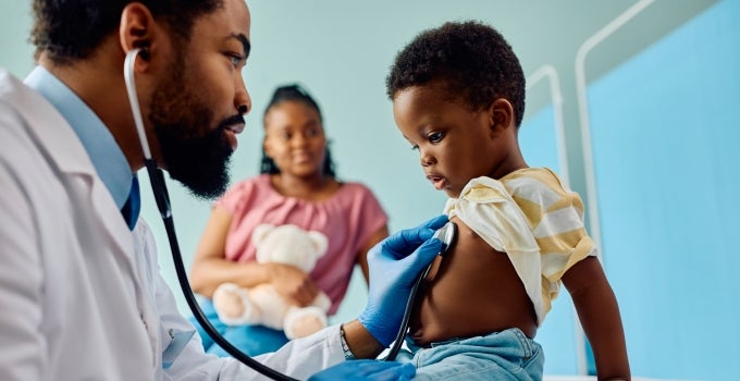 Black male nurse using stethoscope on pediatric patient